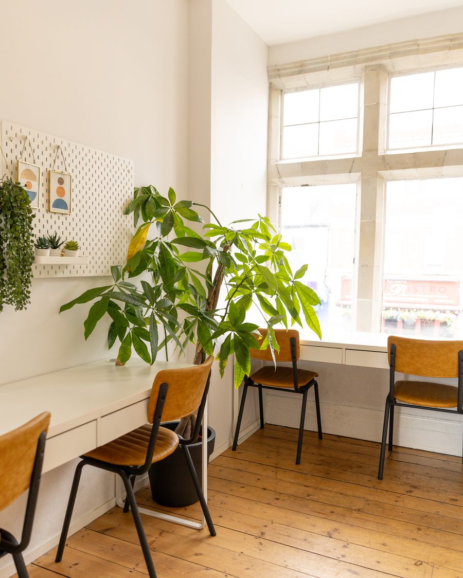 Upstairs workspace with desk, plants and window seating